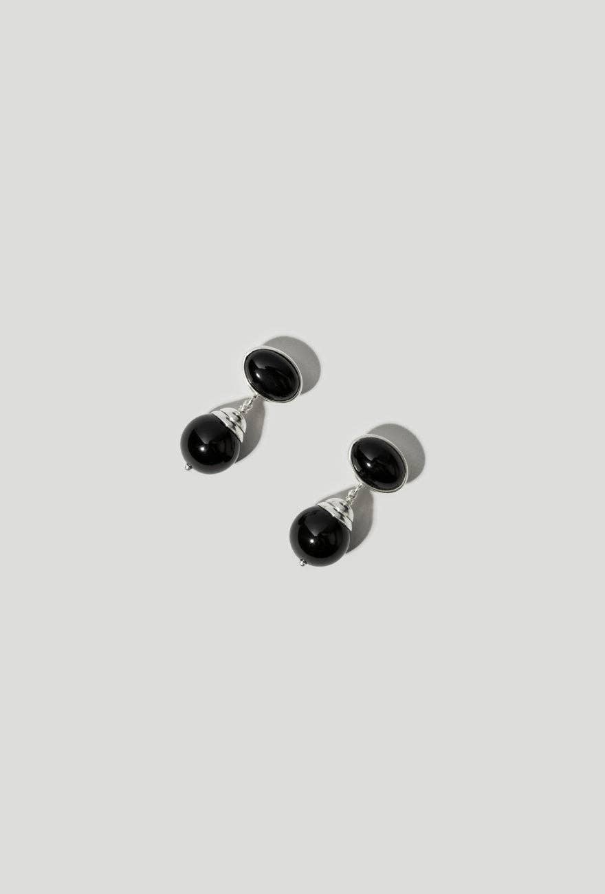 Pair of black earrings on a light gray background
