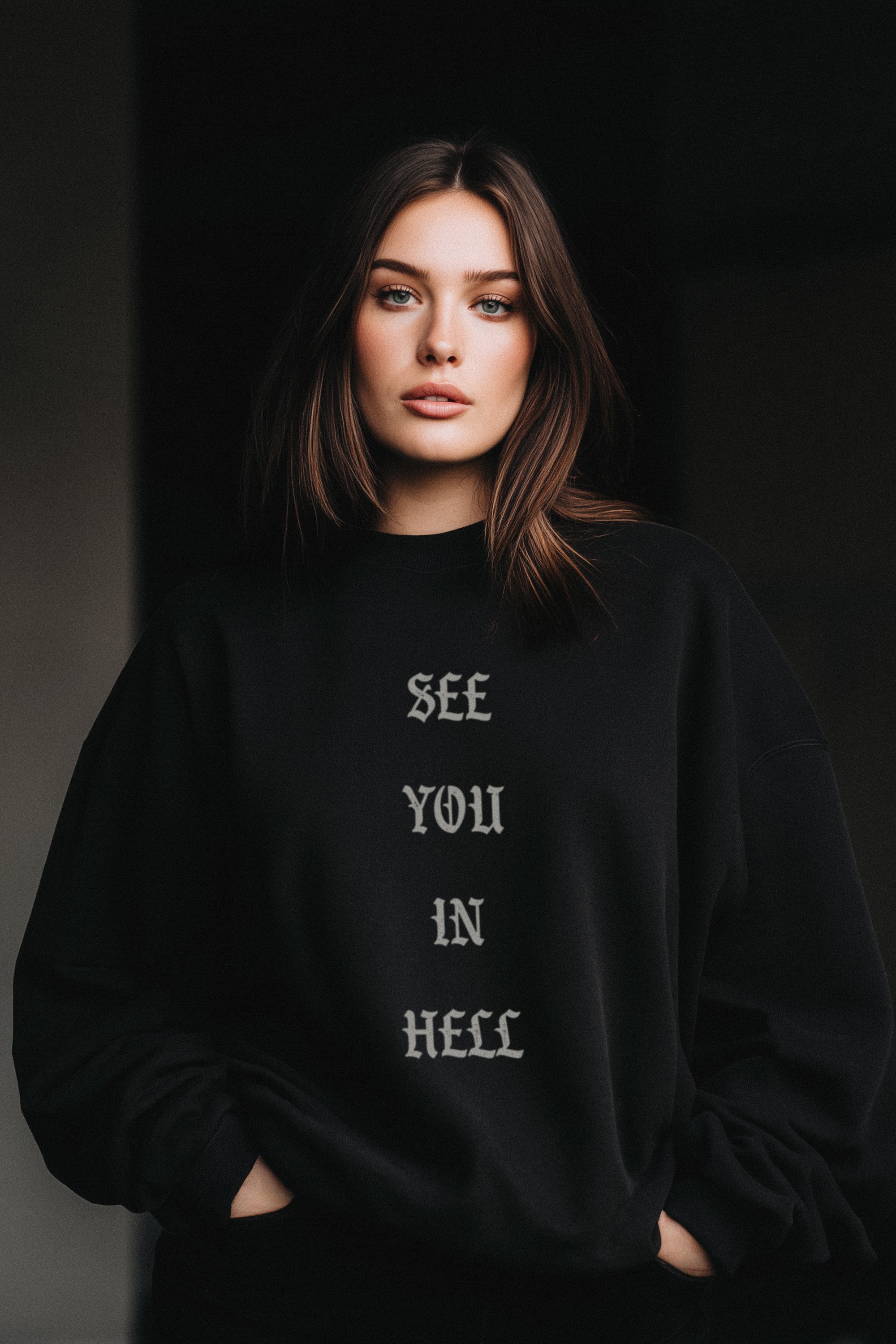 Person wearing a black sweatshirt with text 'SEE YOU IN HELL' on a dark background